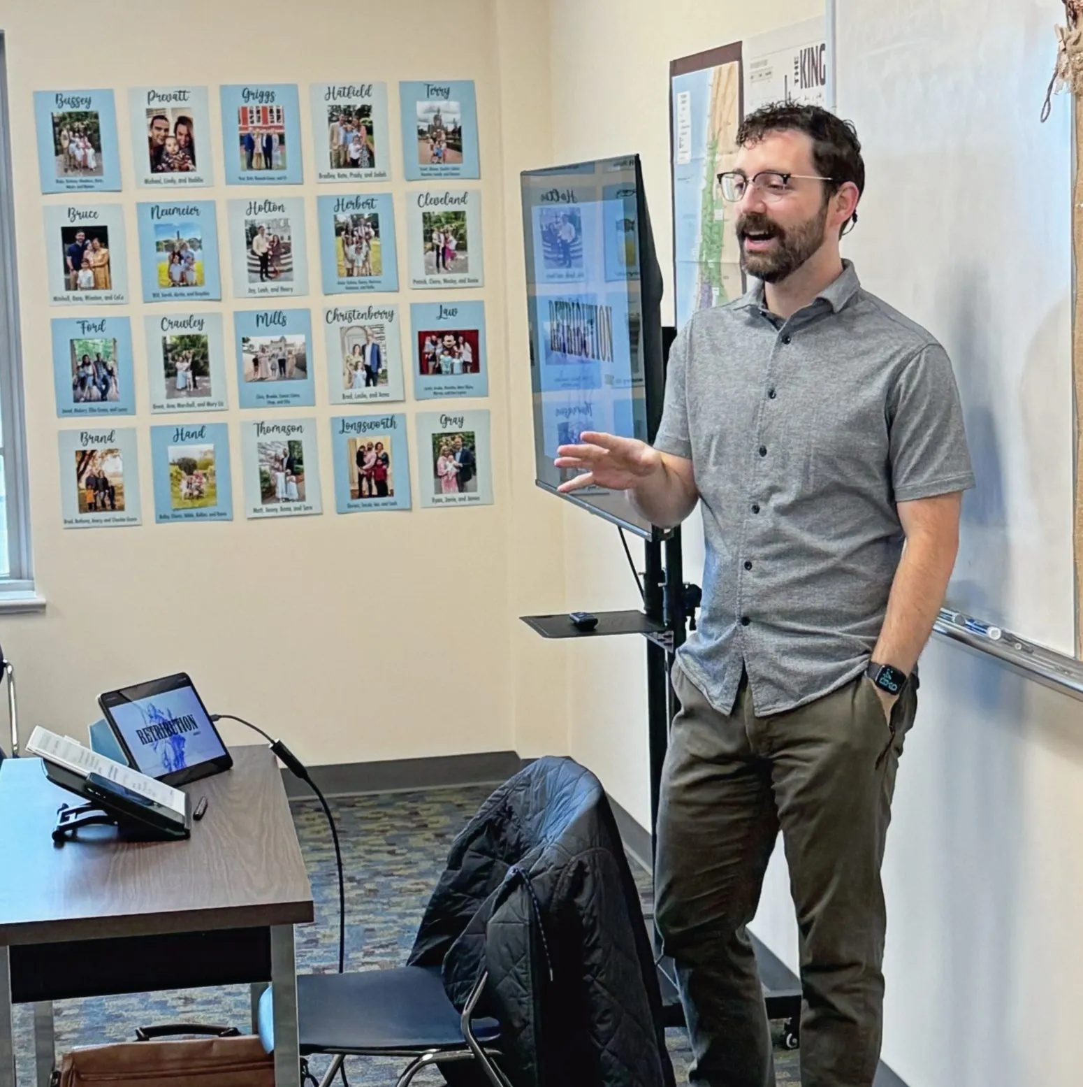 A man teaching in front of a whiteboard in a classroom.