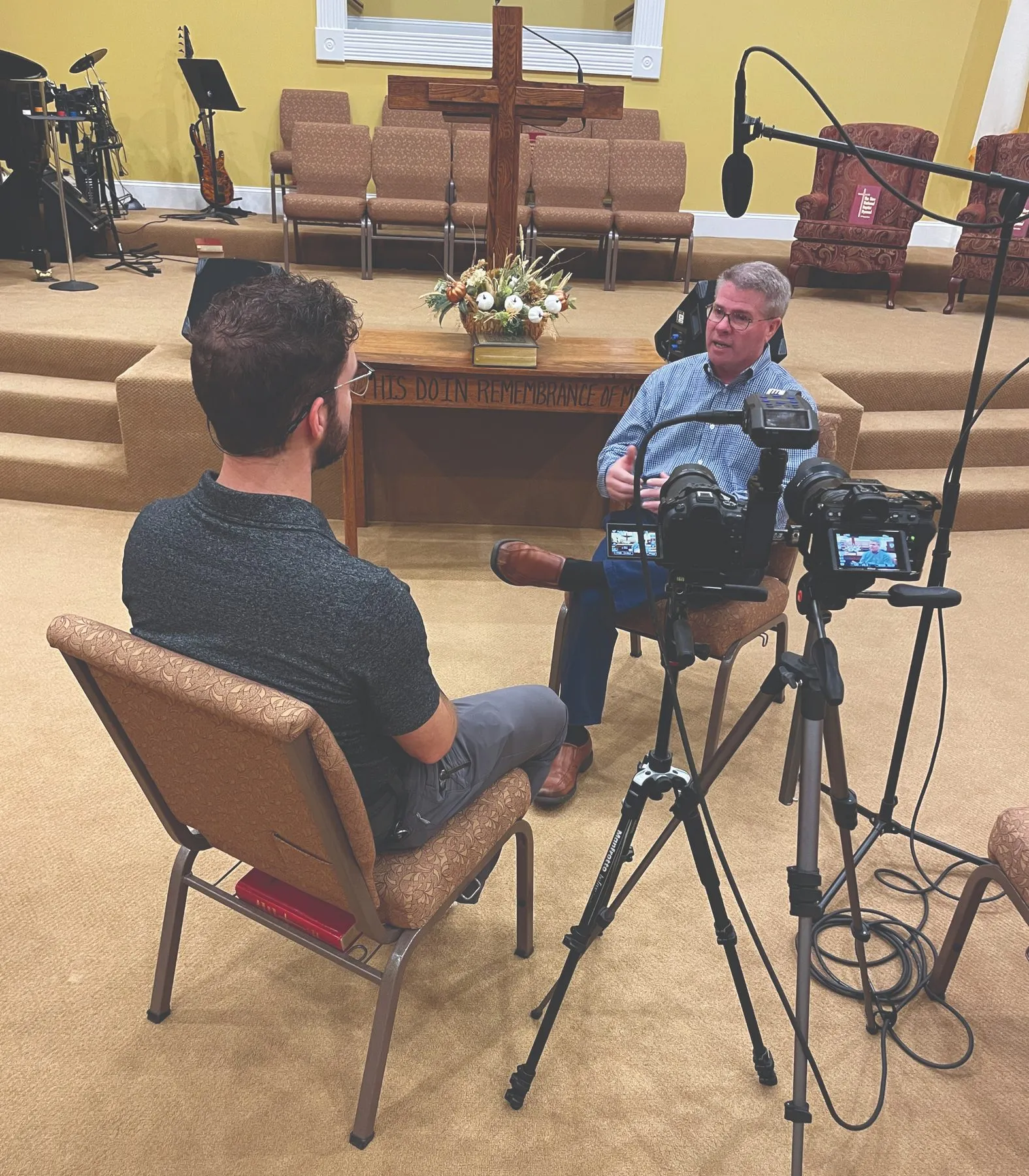 Filming an interview in a church, seen from behind the camera.